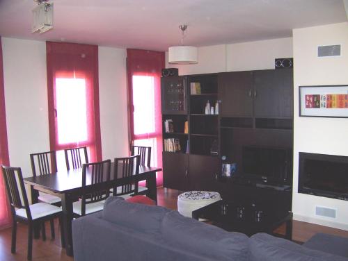 sala de estar con sofá y mesa de comedor en Dúplex 3 dormitorios en Sabiñánigo