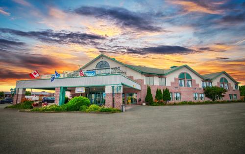 a hotel building with a sunset in the background at Hôtel Travelodge by Wyndham Victoriaville in Victoriaville
