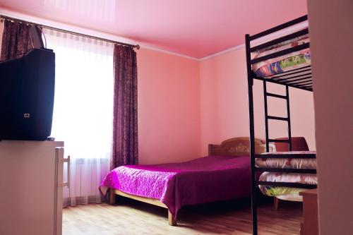 a bedroom with a bunk bed and a television at Malva in Lviv