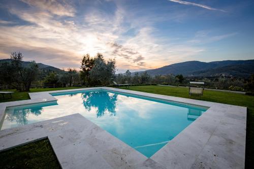 a swimming pool with a view of the mountains at Villa Gaggioleto in Castiglion Fiorentino
