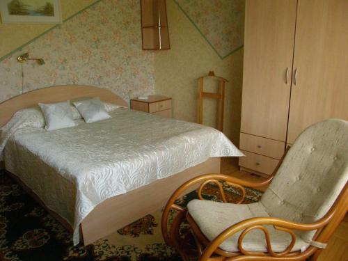 a bedroom with a bed and a chair at Home for Guests Lakštingala in Šiauliai