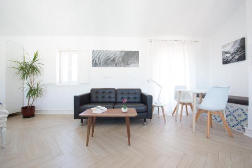 a living room with a black couch and a table at Almamater Lisbon Apartments in Lisbon