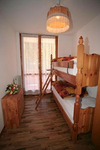 a bedroom with two bunk beds and a window at Residence Valfassa in Canazei