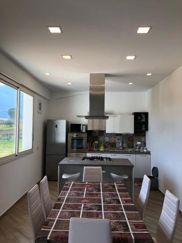 a kitchen with a table with chairs and a stove at Scopello Guidaloca Villas in Scopello