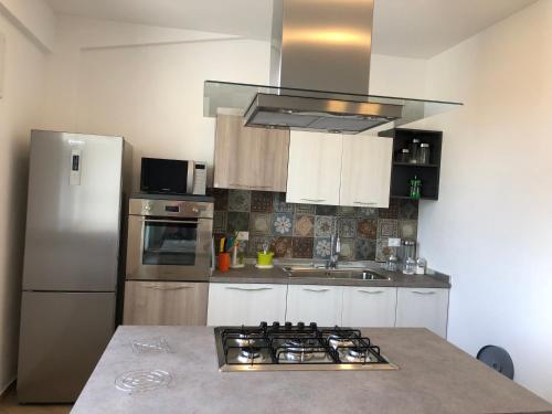a kitchen with a stove and a refrigerator at Scopello Guidaloca Villas in Scopello