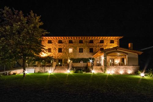 a large brick building with lights in the yard at night at Font del Pas in Beceite