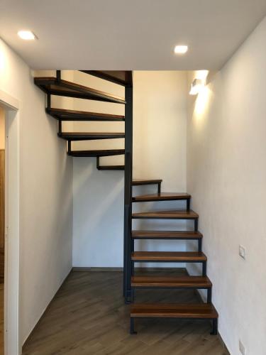 a spiral staircase in a room with wooden floors at Scopello Guidaloca Villas in Scopello