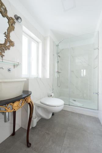 a bathroom with a toilet and a glass shower at Almamater Lisbon Apartments in Lisbon