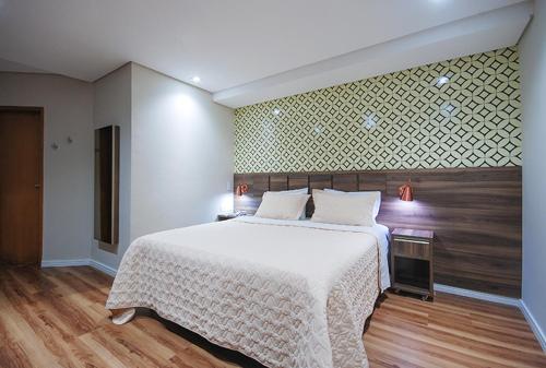 a bedroom with a large bed with a white blanket at Hotel Biz in Sao Paulo