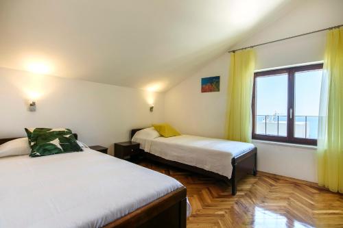 ein Zimmer mit zwei Betten und einem großen Fenster in der Unterkunft Apartments Martina in Primošten