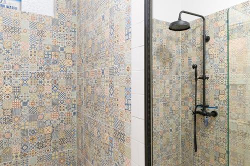 ein Bad mit Dusche und Mosaikfliesen an den Wänden in der Unterkunft Amazing Old Town Chill Out Apt in Warschau