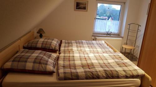 a bedroom with a bed with two pillows and a window at Casa del Sol in Kleve