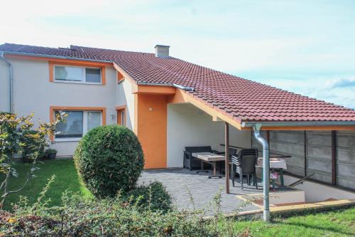 a house with a deck with a table and a roof at Apartmán Marta in Banka