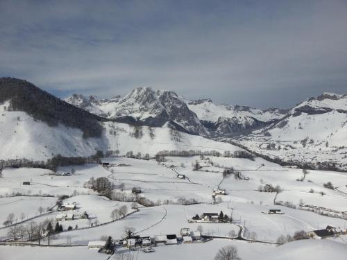 a snow covered mountain range with houses and mountains at Gîte de montagne du Plateau de Lhers- Accueil randonneurs in Accous