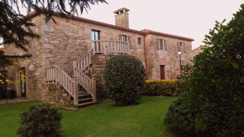 an old stone house with a staircase in the yard at Casa de Barreiro in Teijeiro