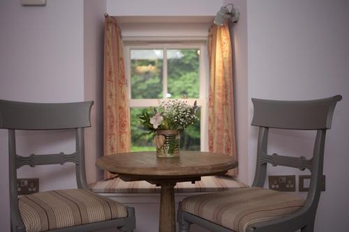 a table with two chairs and a window at The Lodges @ Barra Castle in Inverurie