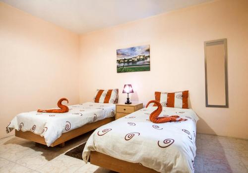 Dos camas en una habitación con cisnes en la cubierta en Victoria Penthouse, en Victoria