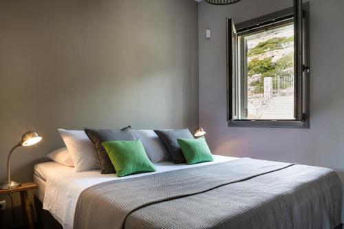 a bedroom with a large bed with green pillows at Myrtos View Apartments in Anomeriá