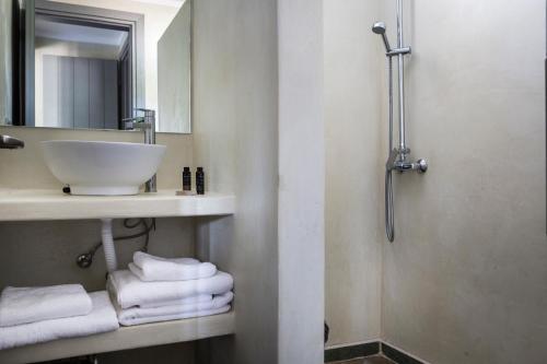 a bathroom with a sink and a mirror and towels at Myrtos View Apartments in Anomeriá