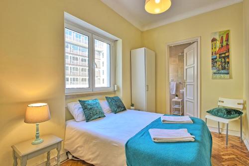 リスボンにあるAlmirante 2 Four Bedroomsのベッドルーム1室(青いシーツと窓付)