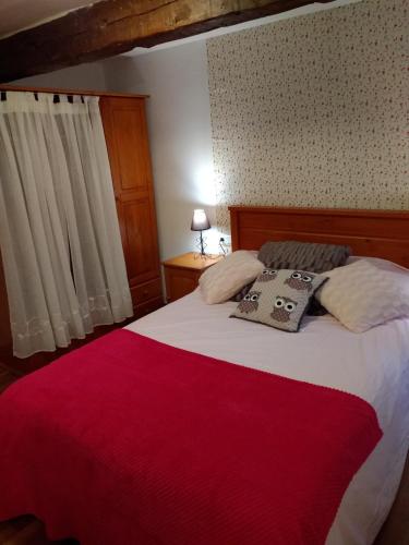 a bedroom with a large bed with a red blanket at Apartamento entreHoces Plaza Mayor in Cuenca