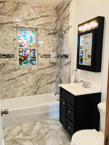 a bathroom with a sink and a tub and a window at Boston Lodge and Suites in Boston