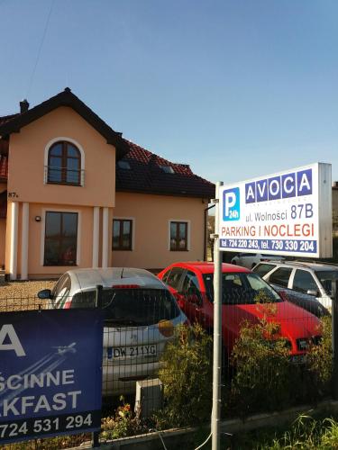 a parking lot with a parking sign in front of a house at Noclegi Avoca in Pyrzowice