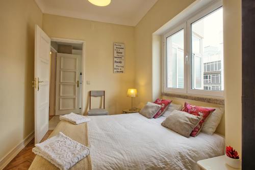 a bedroom with a bed with red pillows and a window at Almirante Top Floor / Almirante Reis Avenue in Lisbon
