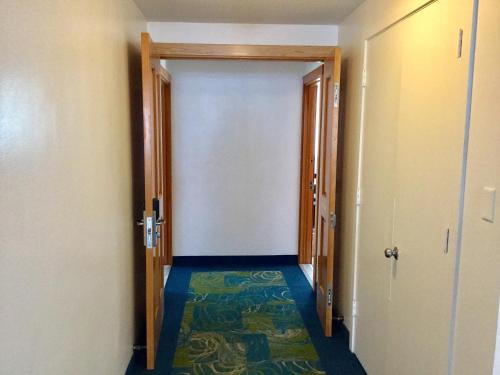 an empty hallway with a door and a carpet at Holiday Surf Hotel (with full kitchen) in Honolulu
