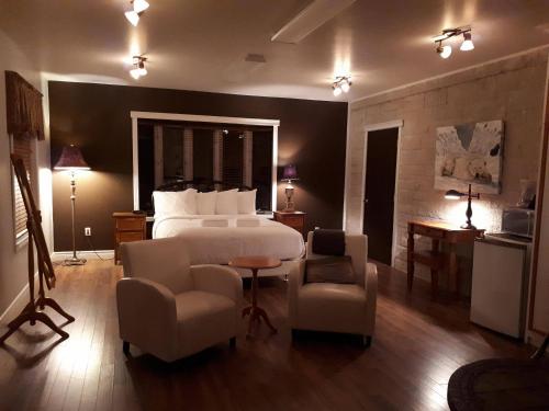 pokój hotelowy z łóżkiem, stołem i krzesłami w obiekcie Auberge des Berges w mieście Saint-Félicien