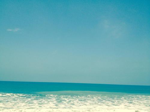 a beach with a blue sky and the ocean at Valdivia Suites in Crucita