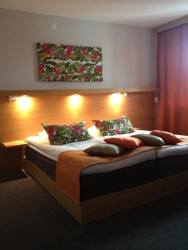 a bedroom with a large bed with pillows at Kumla Hotel in Kumla
