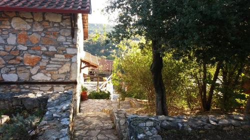 a stone house with a stone wall and trees at Stonehouse 2 Bedroom Chalet on Olympus Amazing View in Pétra