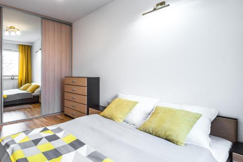 sypialnia z białym łóżkiem z żółtymi poduszkami w obiekcie Apartament 48m w centrum Grójca w mieście Grójec