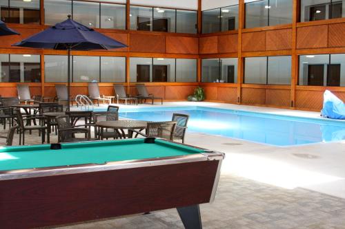Barkers Island Inn Resort & Conference Center في سوبيريور: طاولة بلياردو مع طاولات وكراسي في مبنى