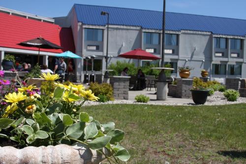 a garden with flowers and people sitting under umbrellas at Barkers Island Inn Resort & Conference Center in Superior