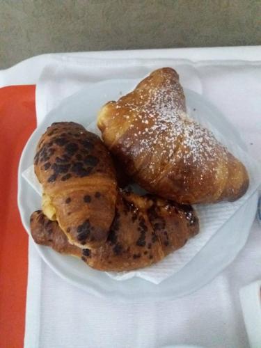 a white plate with pastries and bread on a table at B&B Casa Tua in Naples