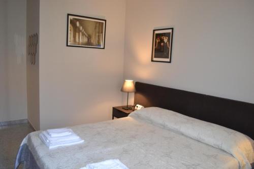 a bedroom with a bed and two pictures on the wall at A Pochi Passi in Venaria Reale