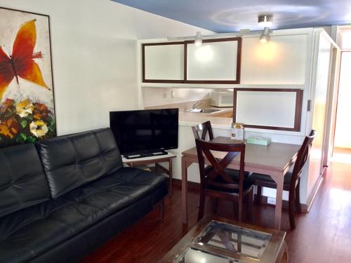 a living room with a couch and a table at Holiday Surf Hotel (with full kitchen) in Honolulu