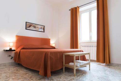 a bedroom with an orange bed and a window at Michelangelo Apartment in Civitavecchia