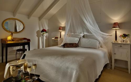 1 dormitorio con 1 cama blanca con dosel en The Peppertree Luxury Accommodation en Blenheim
