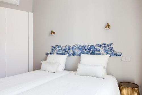 two beds in a room with blue and white at Alfama Sophisticate Flat With Balconies 2Bedrs 2Baths & AC in 19th Century Building Historic Center in Lisbon