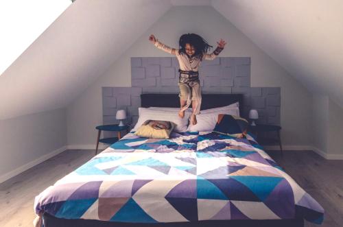 a little girl jumping on top of a bed at The Red Jedi in Lisbon