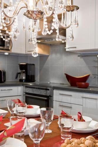 a kitchen with a table with plates and wine glasses at Holiday Club Pyhä HolySuites in Pyhätunturi