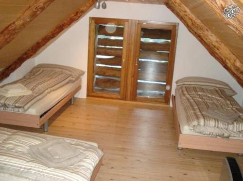 a attic room with two beds and a window at Rustico Aurora in Brontallo