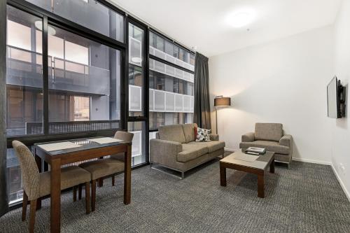a living room filled with furniture and a large window at Melbourne CBD Central Apartment Hotel in Melbourne