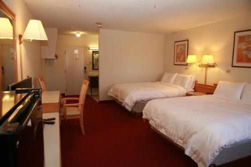 pokój hotelowy z 2 łóżkami i stołem w obiekcie Widus Inn w mieście Swift Current