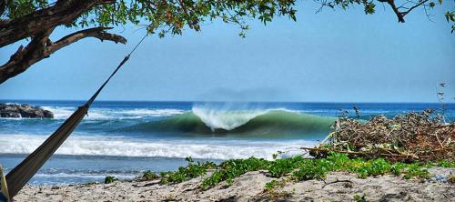 a wave in the ocean with a person riding a wave at Club Surf Popoyo in Popoyo