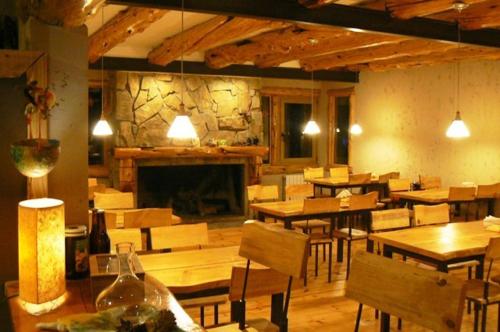 a restaurant with wooden tables and chairs and a fireplace at Ruca Pehuen Eco-Lodge De Montaña in Caviahue