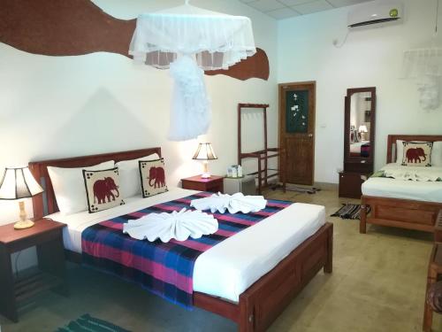 a bedroom with two beds and two lamps at The Nature Park Villa in Sigiriya